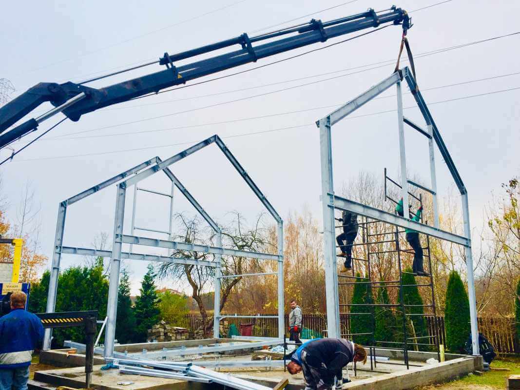 Die Arbeiter montieren die Stahlkonstruktion während der Bauphase; in diesem Fall wurde eine Stahlhauskonstruktion gewählt.