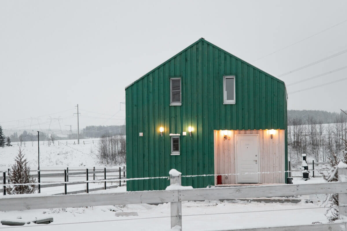 Ein Gewächshaus in einer Winterlandschaft veranschaulicht die Nachhaltigkeit von Häusern in Holzrahmenbauweise.